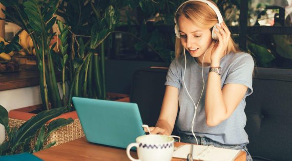 girl-in-headphones-with-laptop-in-cafe-EVE93BR.jpg